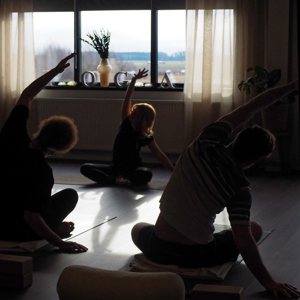 Morgonyoga i YogaSalas studio med fönstret och YOGA-bokstäverna i bakgrunden