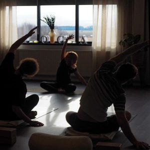 Morgonyoga i YogaSalas studio med fönstret och YOGA-bokstäverna i bakgrunden